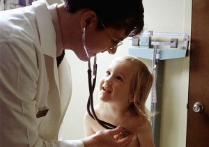 A doctor uses a stethoscope to examine a young girl's heart and lungs. Photo: wiki commons.