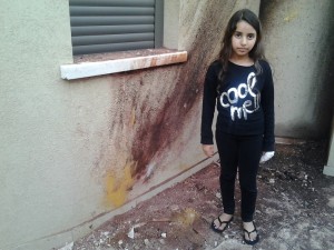 Lian Haziza stands outside her home, hit by a Gaza rocket. Photo: Anav Silverman, Tazpit News Agency