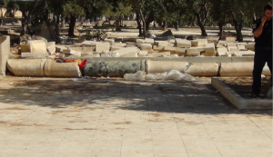Stone column ruins at the Temple Mount, garbage in red, Israeli guard, to the right. Photo: The Temple Institute.
