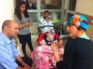 Israeli Economy Minister Naftali Bennett visiting Adele Biton and her family in the Ra'anana hospital. Photo: Naftali Bennett / Facebook.
