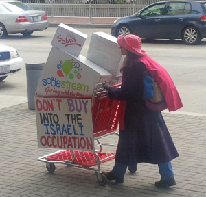 An anti-Israel protester advocating the boycott of Israeli companies SodaStream and Sabra Homous at the 2104 AIPAC Policy Conference. Photo: Algemeiner.