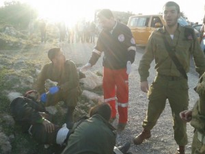 IDF Medical Team Captain Yamin treating Palestinian Arabs after their mini-bus crashed, near Efrat, on April 1, 2014. Photo: IDF.