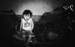 From the TED interview of Emen Mohammed: "Islam Qreqe, 14 months old, sitting on a burnt motorcycle, where three of her family members were targeted, bombed and killed by a rocket fired from an Israeli aircraft drone. Islam's father Moataz Qreqe was riding the motorcycle with his two year old son and brother (Munther Qreqe) when it was targeted by an Israeli rocket during an airstrike at Jamal Abdul Nassesr Street in Gaza City,the bodies were completely scorched. Four months later, Islam was born and named after her two years old brother."