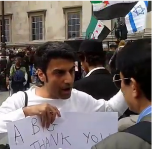 Orim Shimshon in Trafalgar Square, where his tiny Israel flag made a big impact among anti-Assad protesters. Photo: Screenshot.  