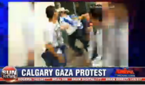 A violent scene in Calgary, Canada, where an Israeli flag was used to throttle an Israel supporter across from a pro-Hamas rally. Photo: Sun News / Screenshot.