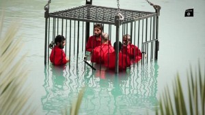 Prisoners are caged and drowned in an ISIS video. Photo: Screenshot.