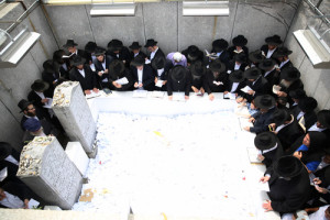 On June 19 in Queens, N.Y., visitors stand beside the gravestone of "the Rebbe," Rabbi Menachem Mendel Schneerson of the Chabad-Lubavitch movement, hours before the 21st anniversary of his death. Photo: Bentzi Sasson/Chabad.org.