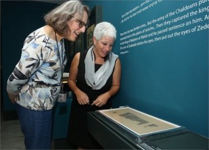 Pnina Shor, Israel Antiquities Authority curator in charge of the Dead Sea Scrolls, and Amanda Weiss, director of the Bible Lands Museum of Jerusalem, oversee the installation of a 2,000-year-old Book of Lamentations scroll, which was on display at the museum for four days. Photo: Bible Lands Museum.