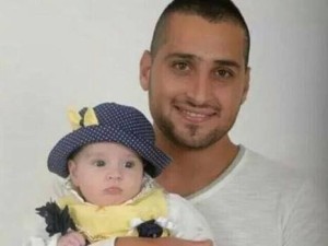 Zidan Nahad Seif with his infant daughter, shortly before his death in the line of duty. Photo: Courtesy of the family to the press.