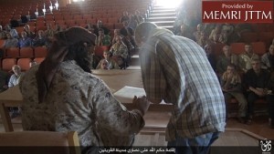 An Islamic State terrorist (left) presides over a Syrian Christian's signing of a "dhimmi" contract. Photo: MEMRI.