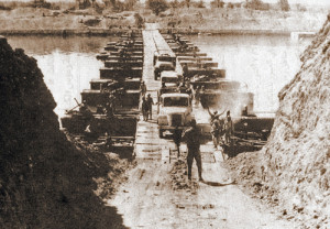 Egyptian military trucks cross a bridge laid over the Suez Canal on October 7, 1973, during the Yom Kippur War. Credit: Wikimedia Commons.