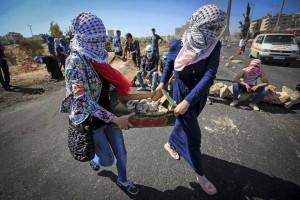 Palestinian girls gather rocks to throw at Israelis. Photo: From the Facebook page, "Palestine Belongs to Palestinians!"