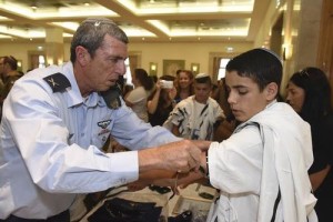 IDF Chief Rabbi Brig. Gen. Rafi Peretz shows Shalom Tiato how to put on his new tefillin at a recent IDF Widows and Orphans Organization (IDFWO) event. Photo: Kobi Koenkas/IDF Widows and Orphans Organization.