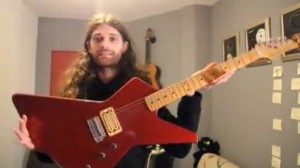 Arnold Nesis posing with his guitar he received from an anonymous donor about 15 years ago. Photo: Screenshot.