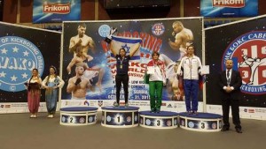 Nili Block (in center) raises her arms and trophy in victory at the October 2015 Kickboxing World Championships in Belgrade, Serbia. Photo: Courtesy Nili Block.