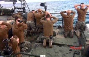 A screenshot of footage showing US sailors seized by the Iranian navy in January. Ruthie Blum argues that " Iran has been milking [the incident] for all ‎its worth over the past month. Photo: Screenshot.