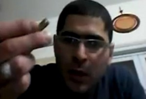 Arab Terrorist Nashat Milhem holds a bullet in a video recovered from his cell phone. Photo: Screenshot via Shin Bet.