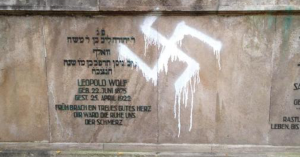 A gravestone at the Jewish cemetery in Hanover that was dubbed with a swastika in 2015. The same cemetery was vandalized three times in three months. Photo: Everyday Vandalism.