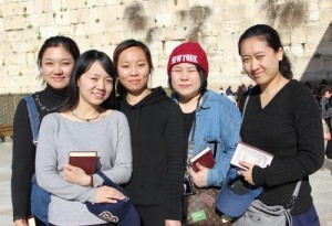 From left to right, five new Chinese immigrants to Israel—Li Yuan, Yue Ting, Li Jing, Li Chengjin, and Gao Yichen—stand in front of the Western Wall. Photo: Laura Ben-David/Courtesy of Shavei Israel.