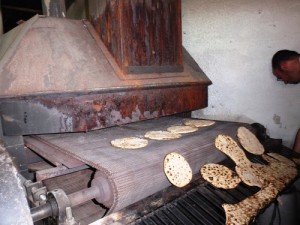 Hand-made matzah comes out of the oven. Photo: Ariel Palmon via Wikimedia Commons.