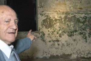 Shmuel Matza, now 89, points to his carvings in the interior wall of Jerusalem's Kishle prison decades earlier. Photo: Maayan Jaffe-Hoffman.