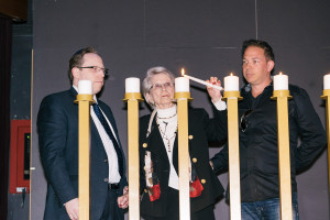 Flanked by grandsons Dan Glassman and Jason Hecht, survivor Stephania Hecht lights a candle in commemoration of Holocaust Remembrance Day at the Museum of Jewish Heritage. May 4, 2016. Photo: Pako Dominguez.