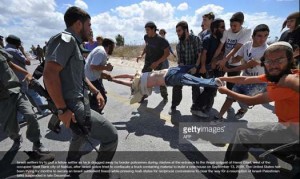 The original photo of Jewish settlers being evacuated from an outpost by Israeli security forces, doctored by the Palestinian Authority Health Ministry. Photo: Getty Images.