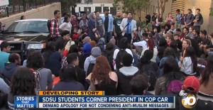 San Diego State University President Elliot Hirshman seen trapped inside a police vehicle by anti-Israel protesters. Photo: Video Screenshot.