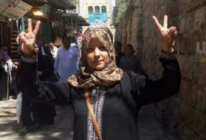 Suhair Halabi flashes “V” for “Victory” signs with both hands at the site where her son, Muhannad, carried out a deadly terrorist attack. Photo: Facebook.