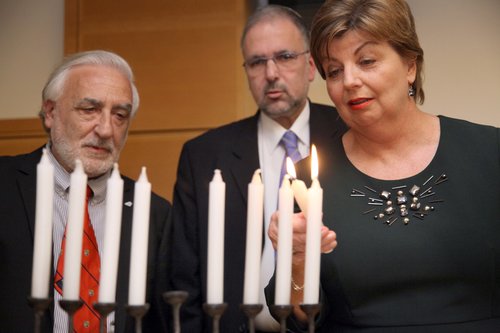 Irish Ambassador to Israel Alison Kelly lights the Hanukkah menorah with former Irish Ambassador to Ireland Boaz Modai (center) and Ireland Israel Friendship League Chairman Malcolm Gafson (left) at an Ireland Israel Friendship League/Open University event to mark the 40th anniversary of Israel-Irish diplomatic exchanges. Photo: Ireland Israel Friendship League.